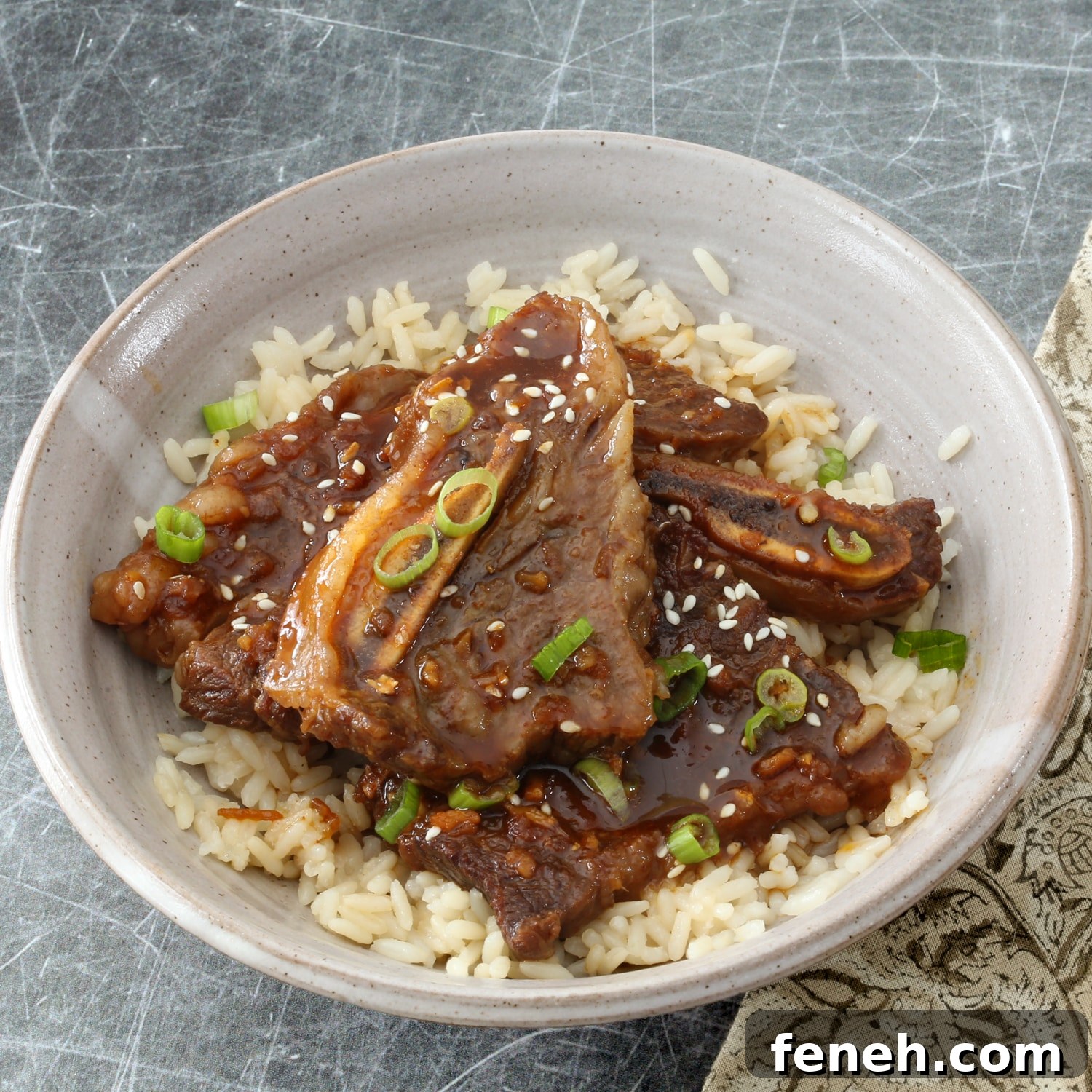 A serving of Instant Pot Korean short ribs on rice with green onion garnish.