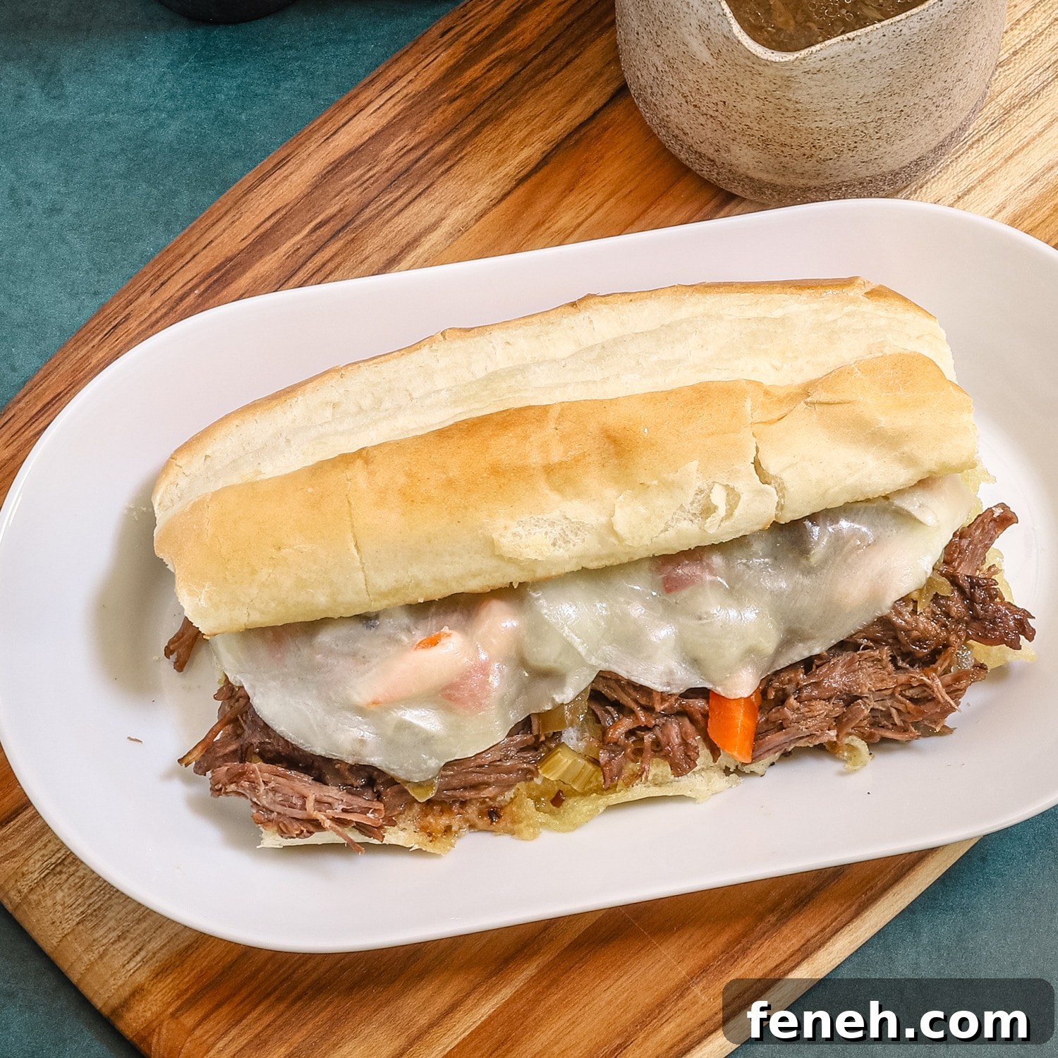 An Italian beef sandwich with a Provolone cheese topping.