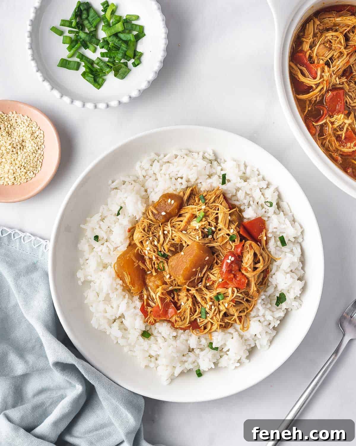 Overhead view of a plate of rice with crockpot pineapple chicken on top.