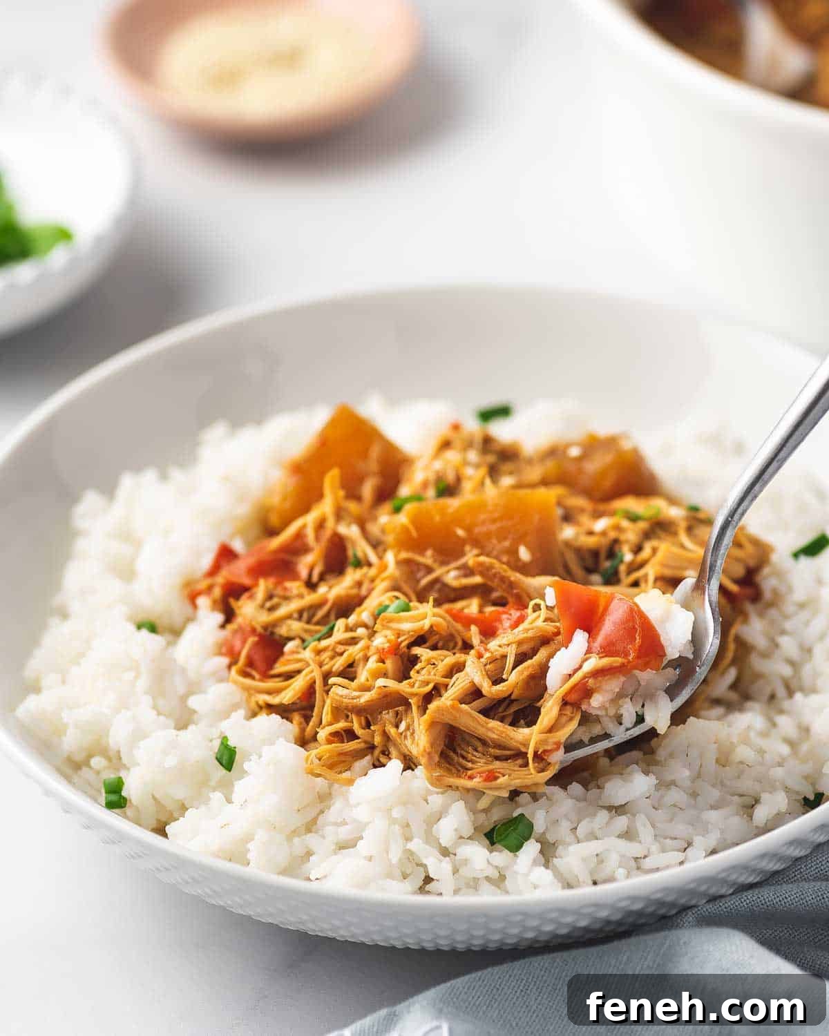 Close up of a plate of rice with pineapple chicken with a spoon lifting up a bite.