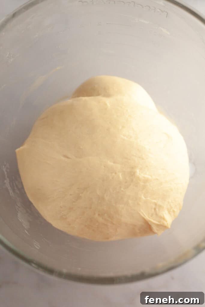 Cinnamon roll dough in a glass bowl.