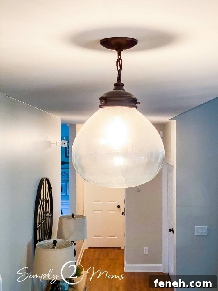 close up of hanging light fixture hanging from hallway ceiling before cleaning