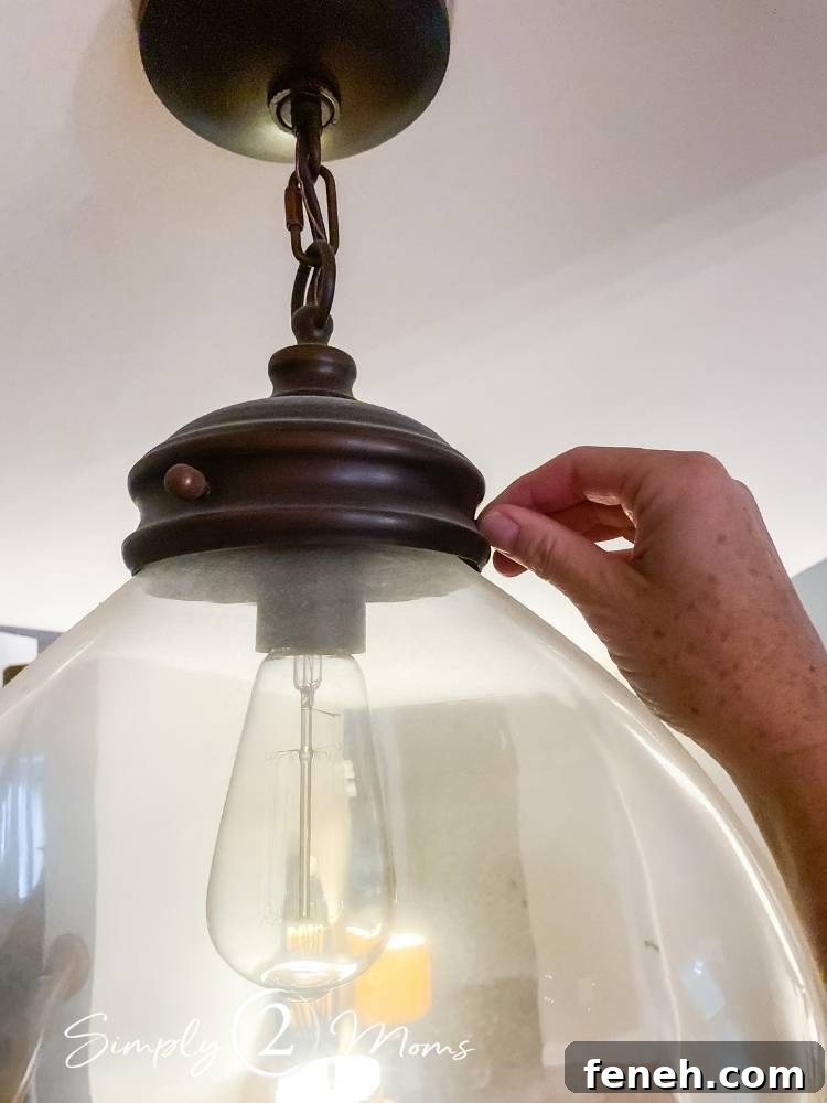 removing glass globe from hanging light fixture for cleaning it