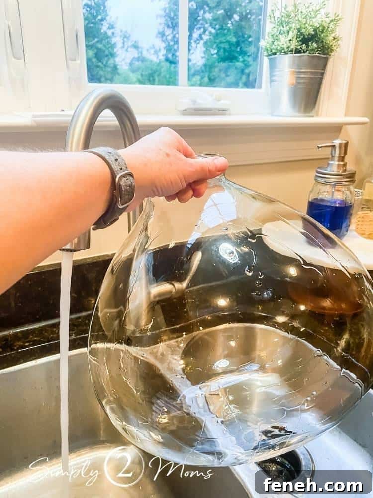 glass globe of hanging light fixture after cleaning in kitchen sink