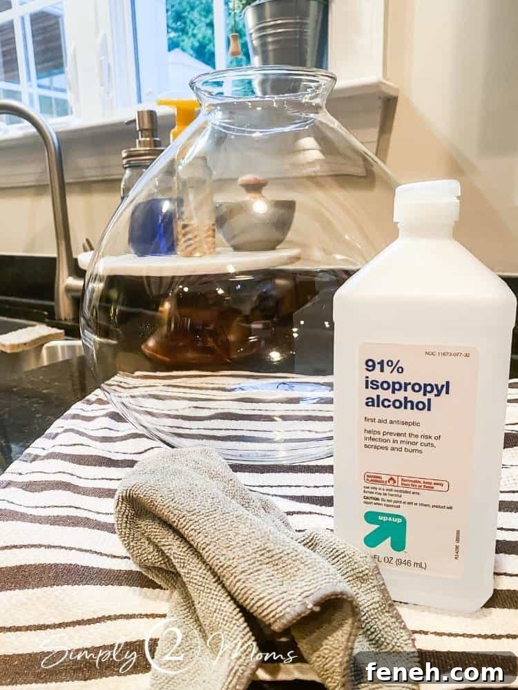 bottle of rubbing alcohol and microfiber cloth on counter next to glass light fixture