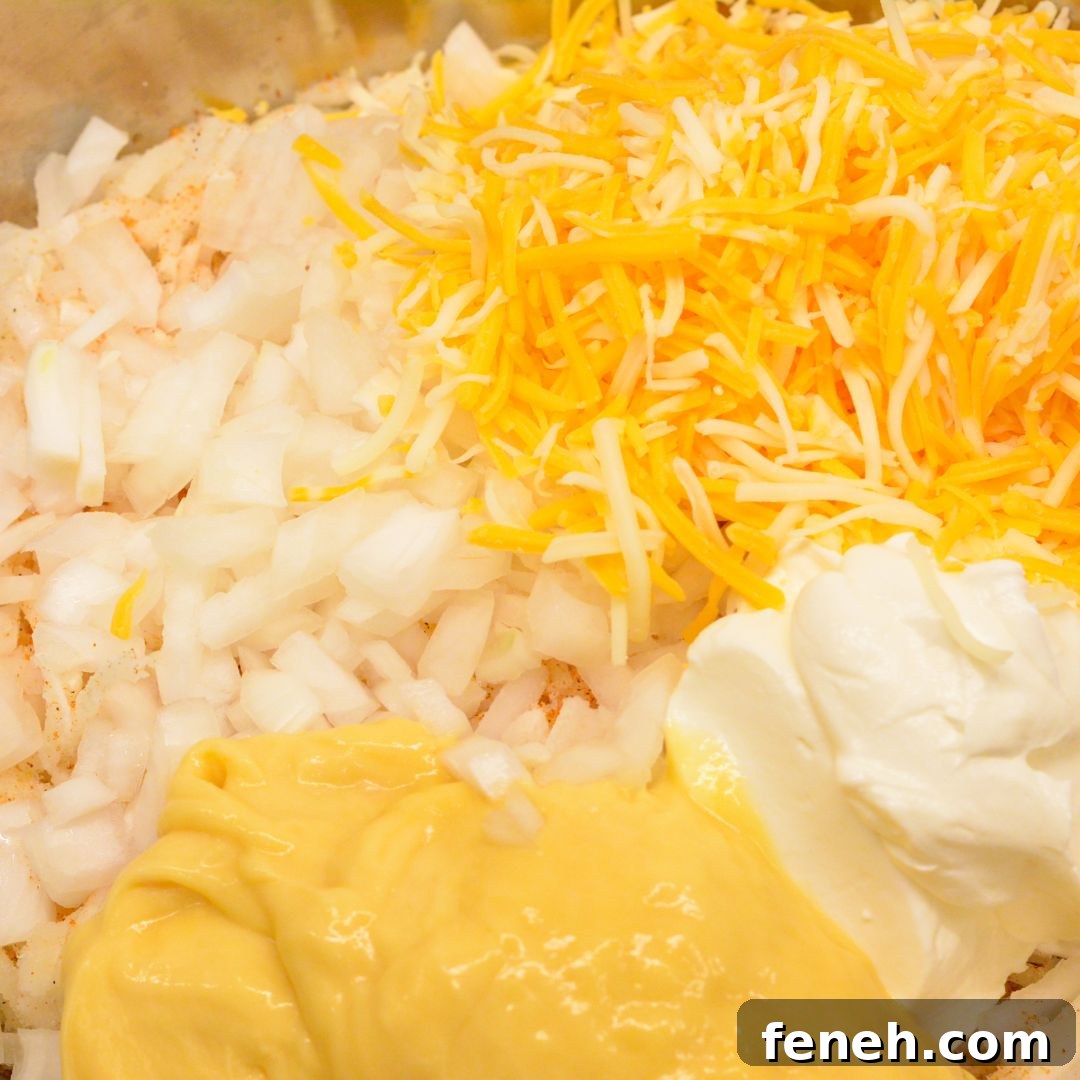 Mix Everything Together: In a large mixing bowl, combine the hash browns, cream of chicken soup, shredded cheddar cheese, sour cream, diced onion, melted butter, and black pepper. Stir until well combined.