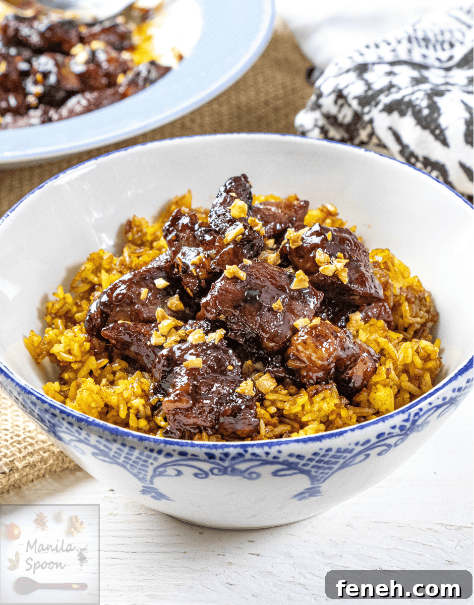 Beef Salpicao (Filipino Garlic and Butter Steak Bites) over yellow rice