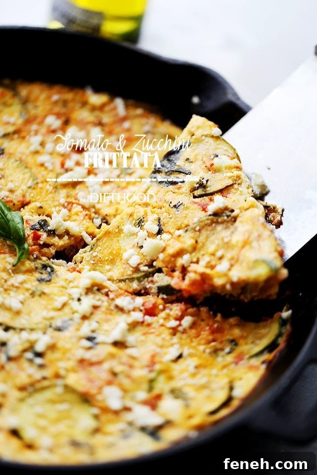 A slice of zucchini frittata being lifted from a cast iron skillet.
