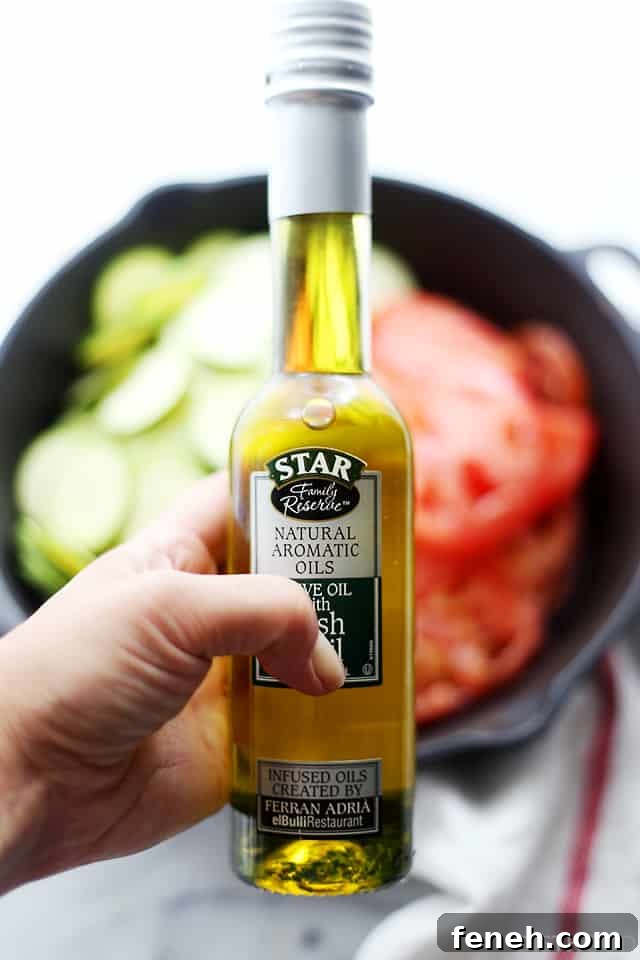 A hand holding up a bottle of basil-infused olive oil.