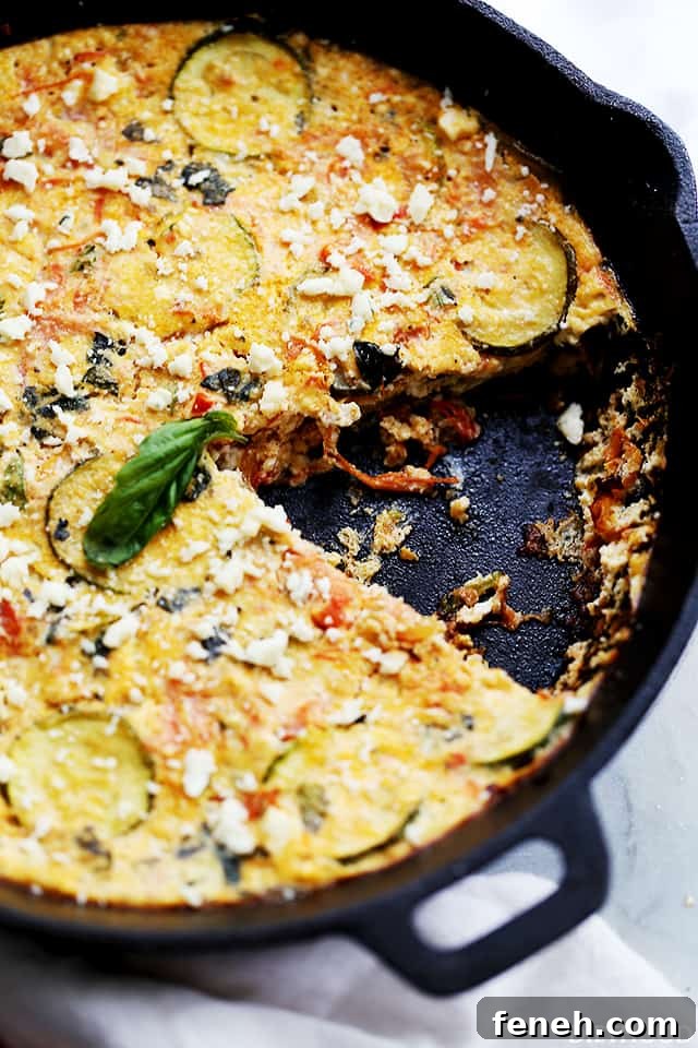 Zucchini frittata in a cast iron skillet with a slice missing.