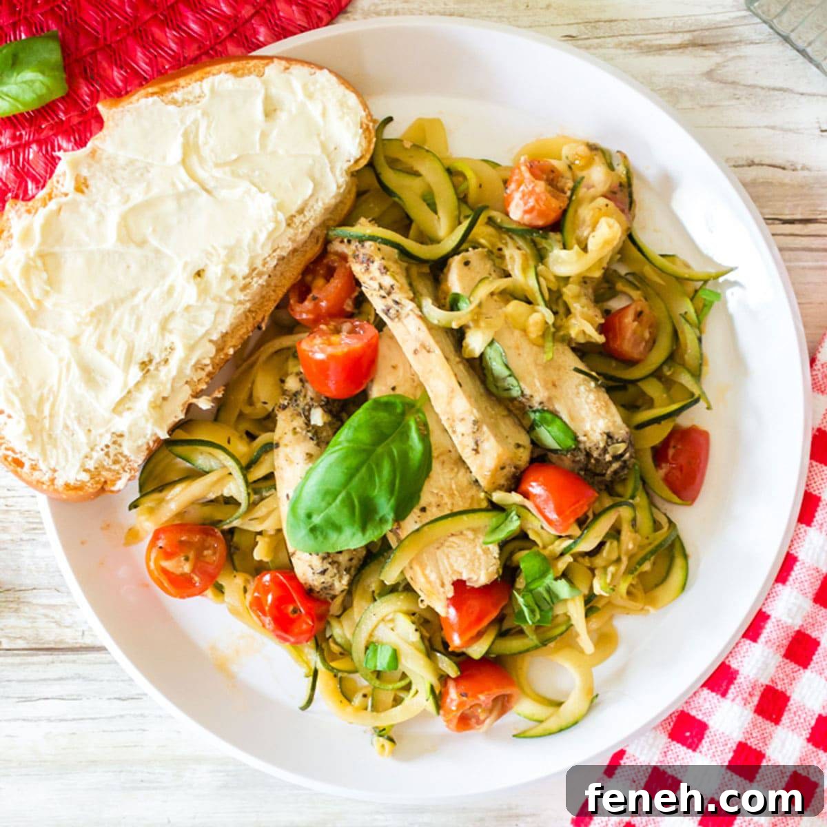Plate of zucchini noodles with a slice of bread.