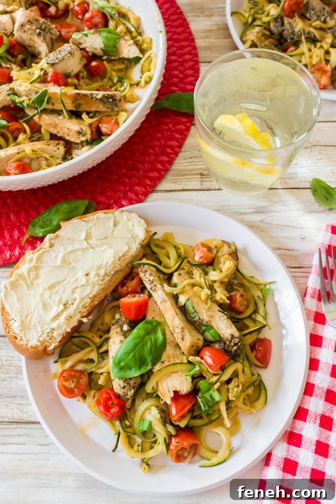 Serving of zucchini noodles with chicken and a glass of ice water.