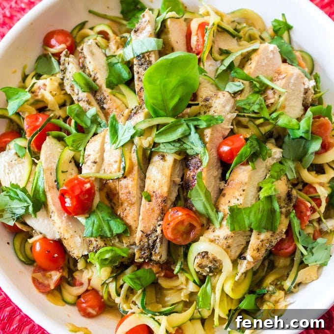 Bowl of chicken covered with shredded basil.