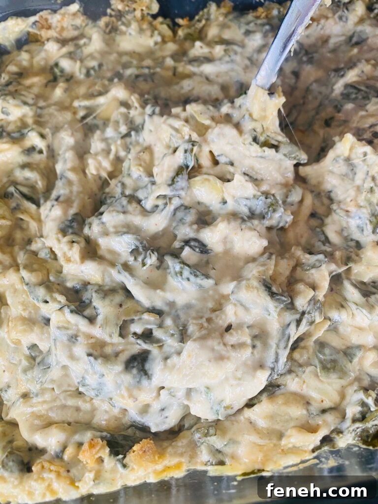 stirring the Smoked Spinach and Artichoke Dip