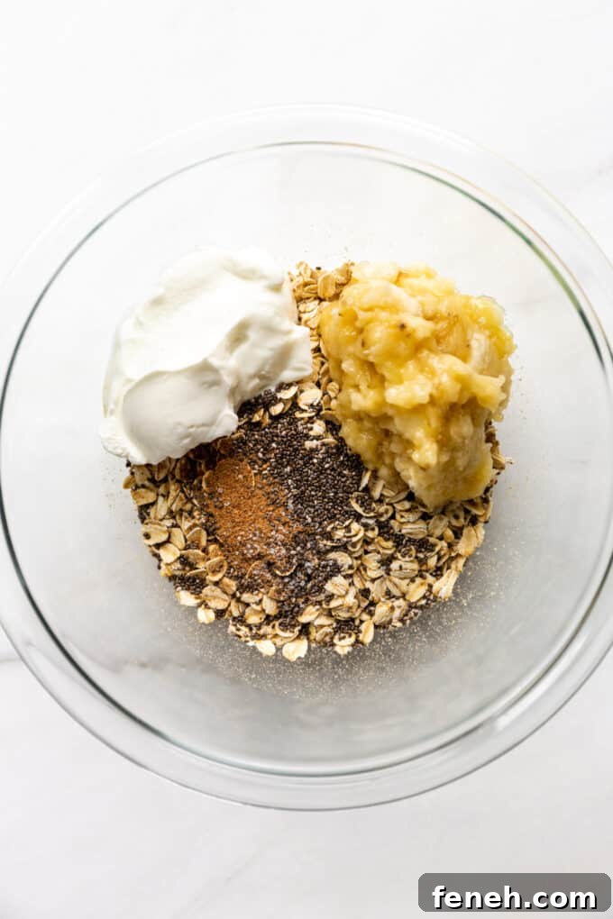 oats, chia seeds, nutmeg, yogurt and banana in a mixing bowl