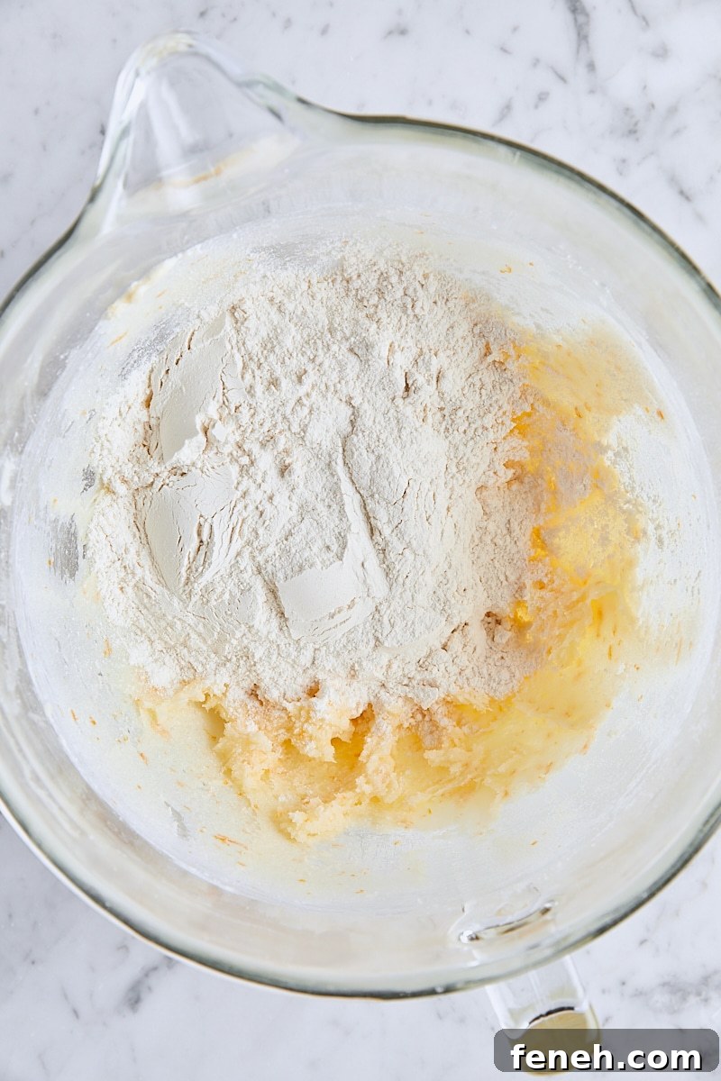 Flour added to shortbread dough in glass mixing bowl