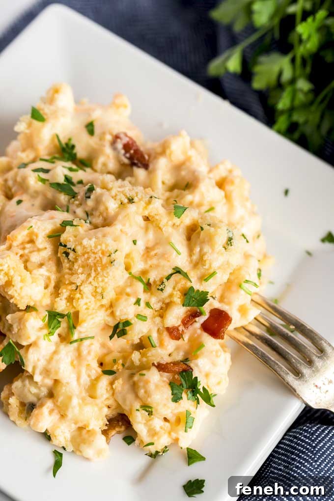 A serving of homemade mac and cheese carbonara on a white plate.