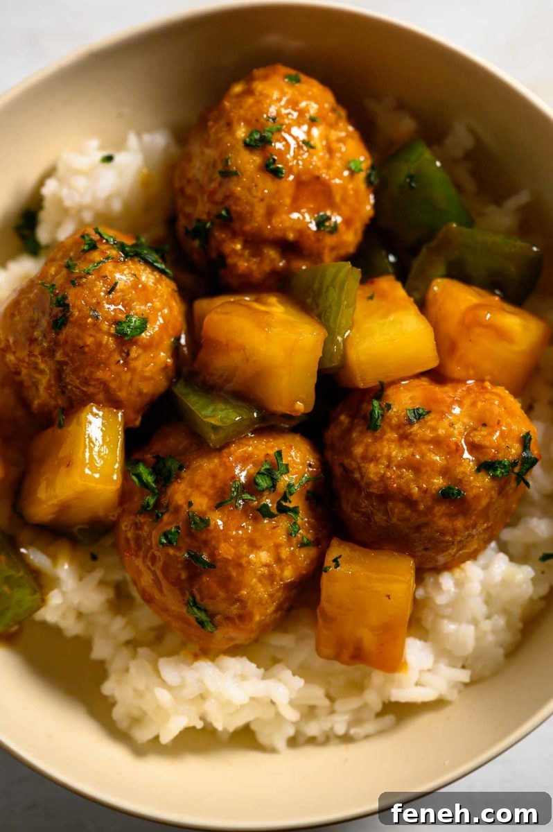 Teriyaki Pineapple Meatballs over rice in a bowl.