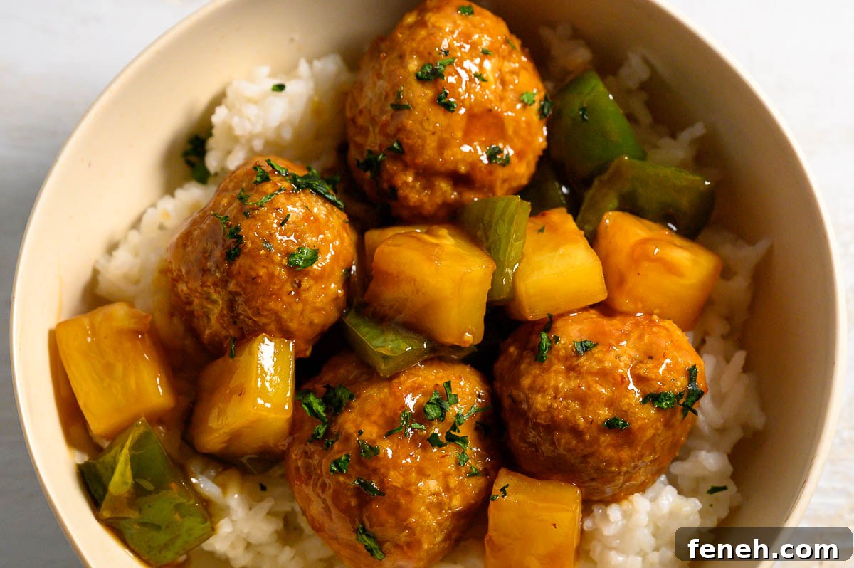 Teriyaki Pineapple Meatballs over rice in a bowl.