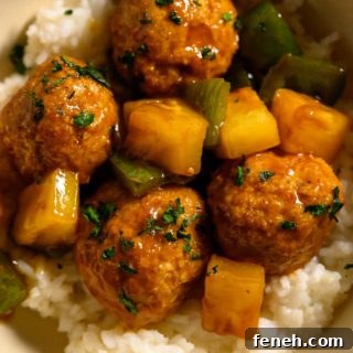 Teriyaki Pineapple Meatballs over rice in a bowl.