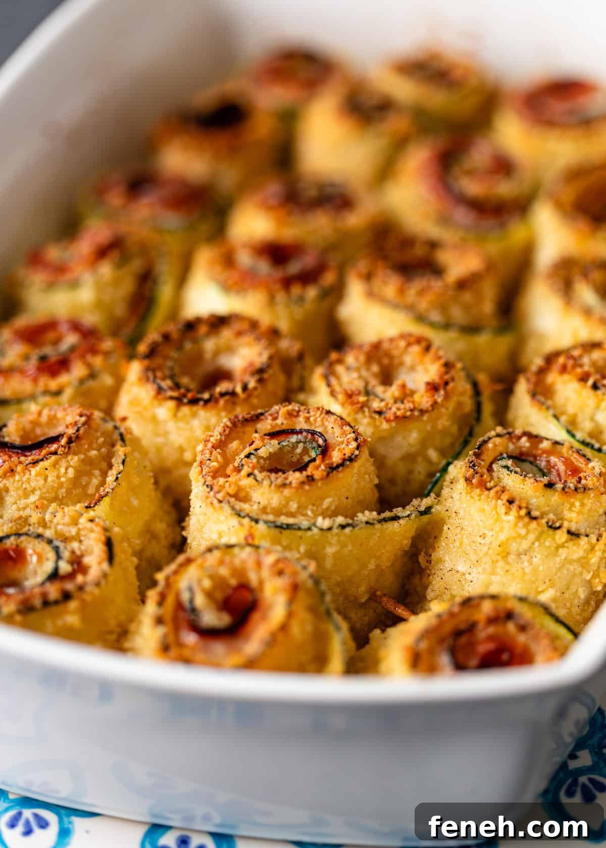 closeup: crispy zucchini rolls in a baking dish after baking