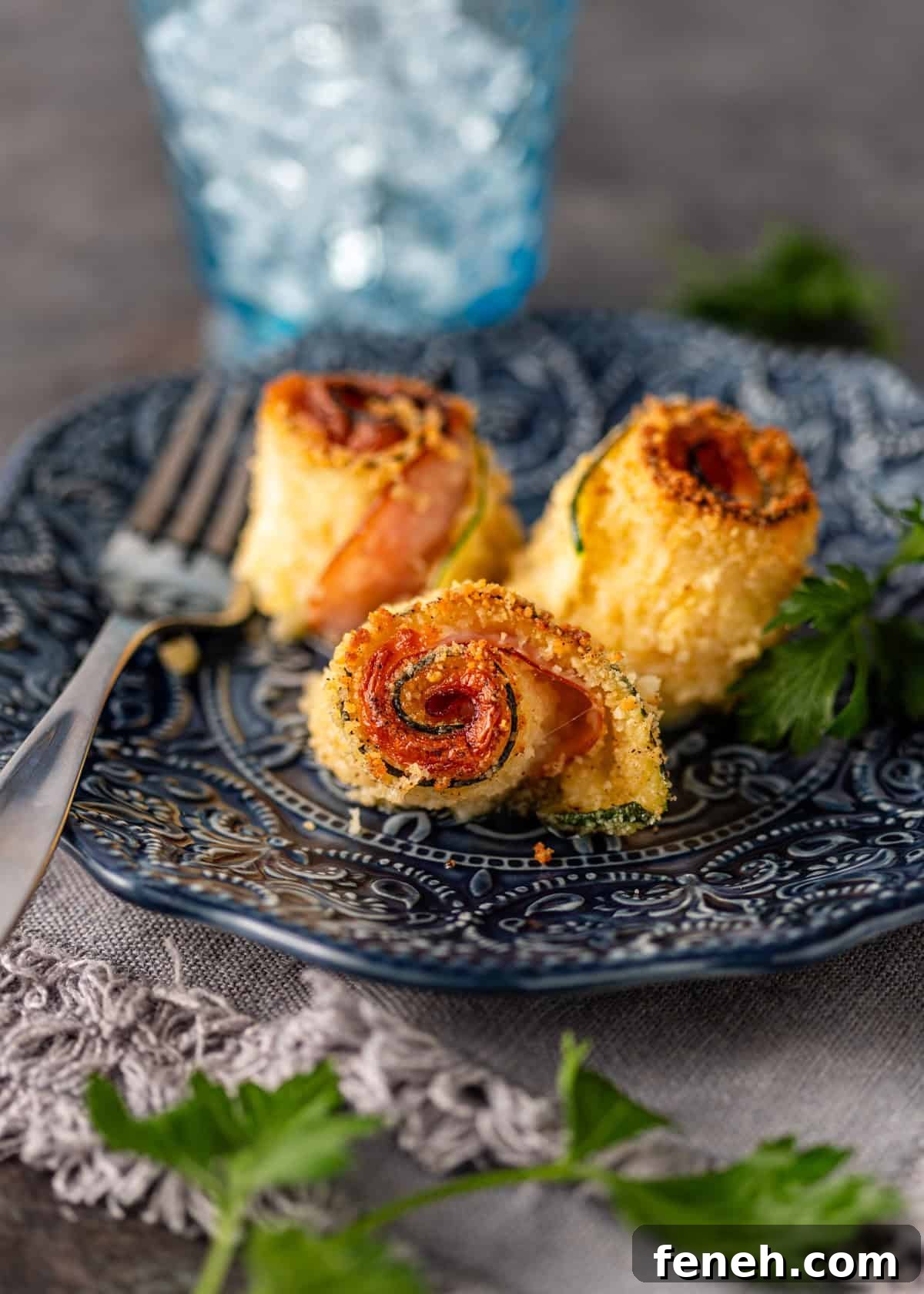 closeup: a serving of my zucchini roll recipe on a blue ceramic plate