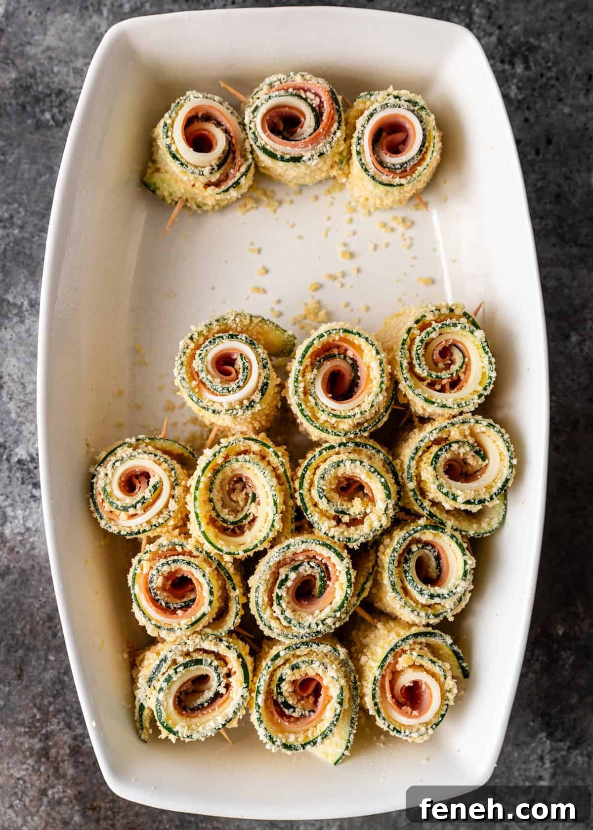 overhead process shot: zucchini involtini rolled up and ready to bake