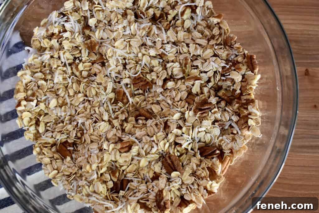 overhead photo of rolled oats, nuts, and brown sugar in a glass mixing bowl. 