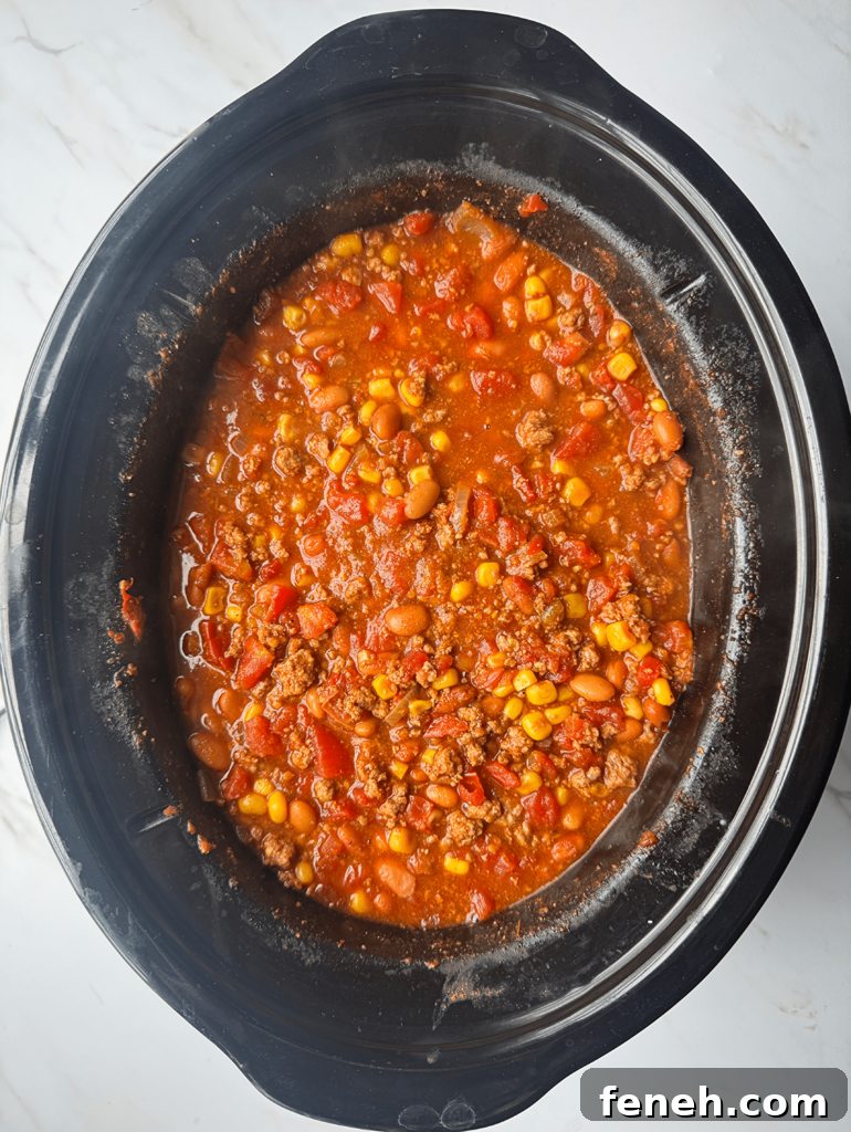overhead shot of cooked taco chili in a black slow cooker