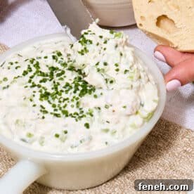 Whitefish salad with chopped chives in bowl on table.