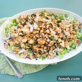 Roasted Cauliflower and Chickpea Salad with Tahini Dressing in white bowl on table.