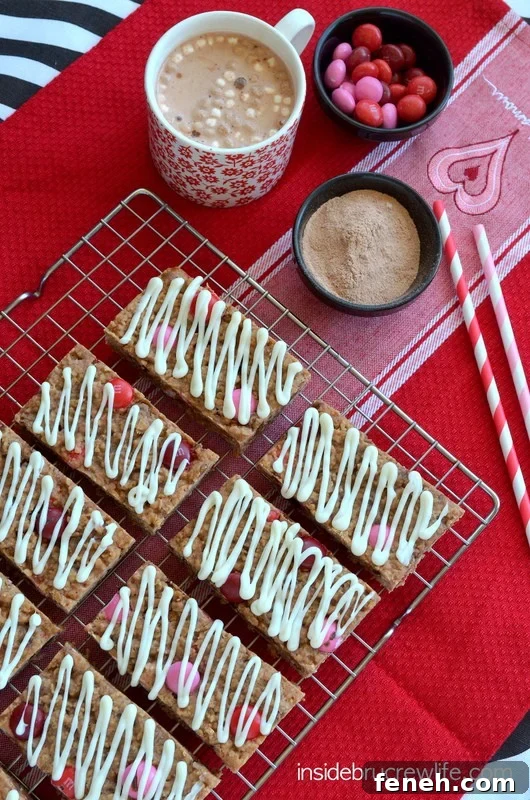 Overhead picture of a wire rack with Raspberry Hot Chocolate Granola Bars with white chocolate drizzles on it.