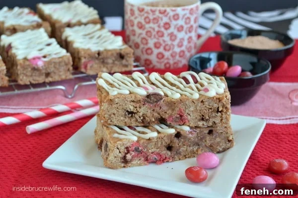 Two Raspberry Hot Chocolate Granola Bars on a white plate with more bars behind it.