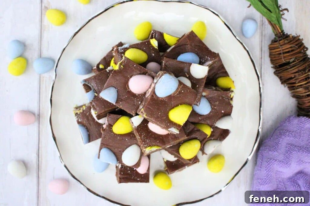 overhead view of mini egg fudge stacked on a plate surrounded by mini candy eggs