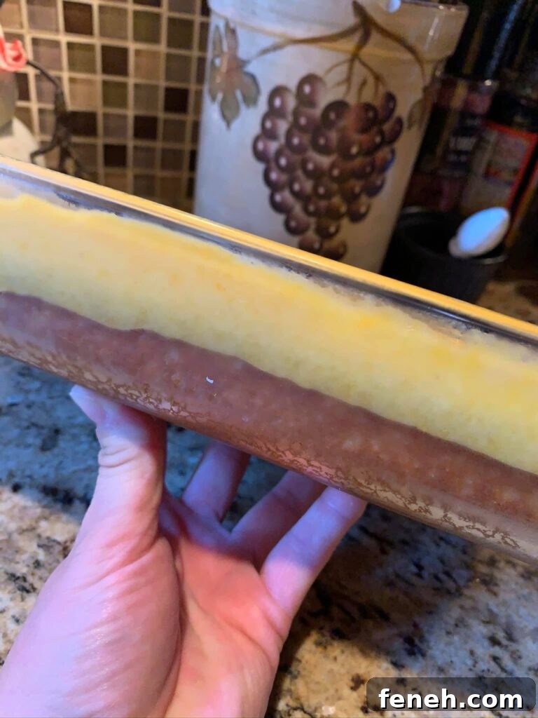 The cake with the pudding on top in a glass dish seen from the side so the layers are shown off