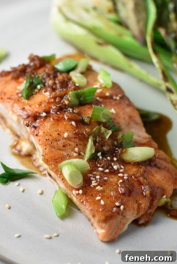 A pan friend teriyaki salmon on a grey plate.