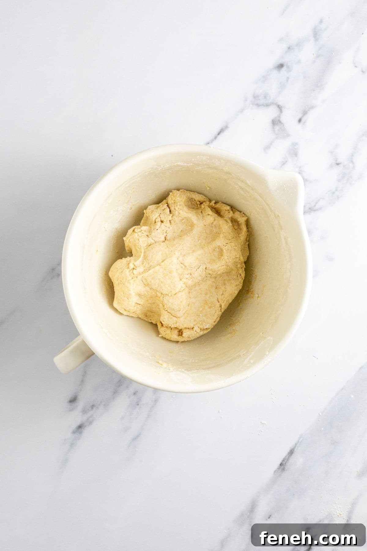 Crispy Whole Wheat Sourdough Crackers Recipe 5 A medium sized cream batter jug filled with a rough dough for making whole wheat sourdough crackers.