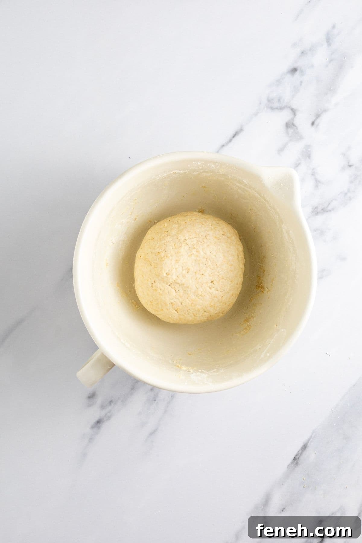 Crispy Whole Wheat Sourdough Crackers Recipe 6 A medium sized cream batter jug filled with a ball of smooth dough for making whole wheat sourdough crackers.