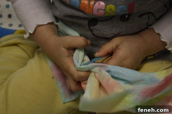 toddler putting paper towel into clothespin