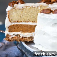 a slice of pumpkin pie layer cake coming out from cake platter.
