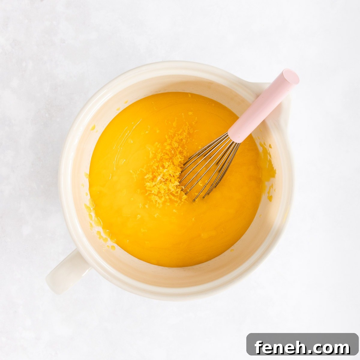 The lemon zest being added into the lemon curd.
