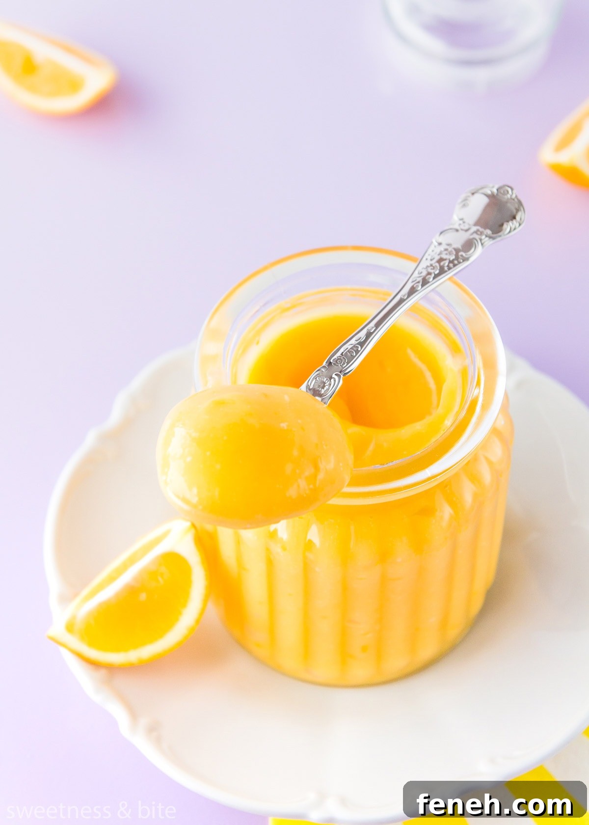 A spoonful of thick lemon curd resting on the top of a jar.