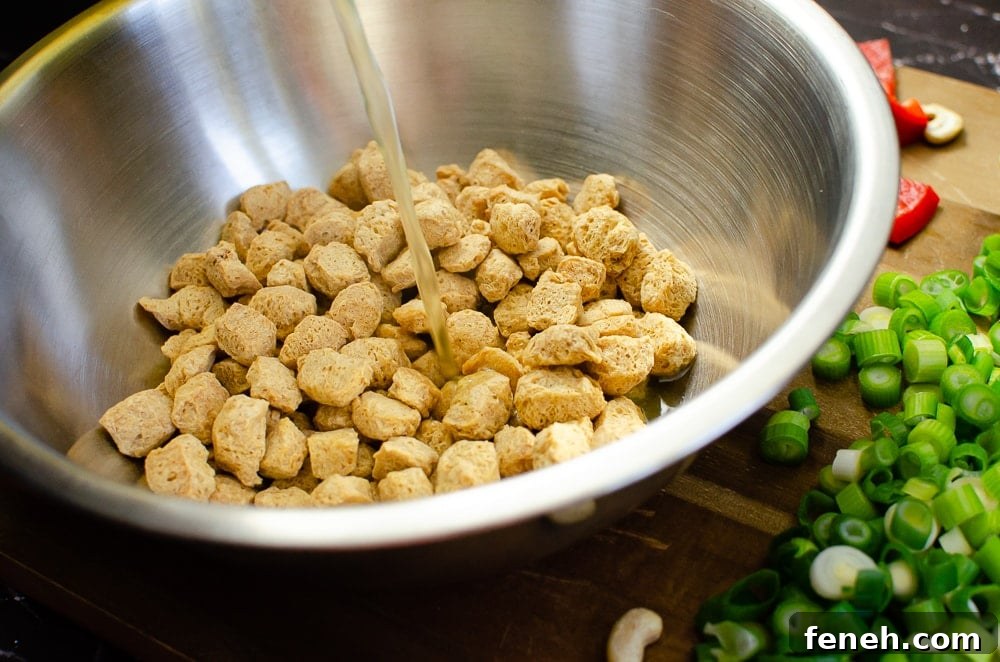 Textured Vegetable Protein in a silver bowl being soaked with vegetable stock