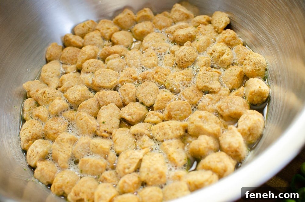 Textured Vegetable Protein in a silver bowl being soaked with vegetable stock