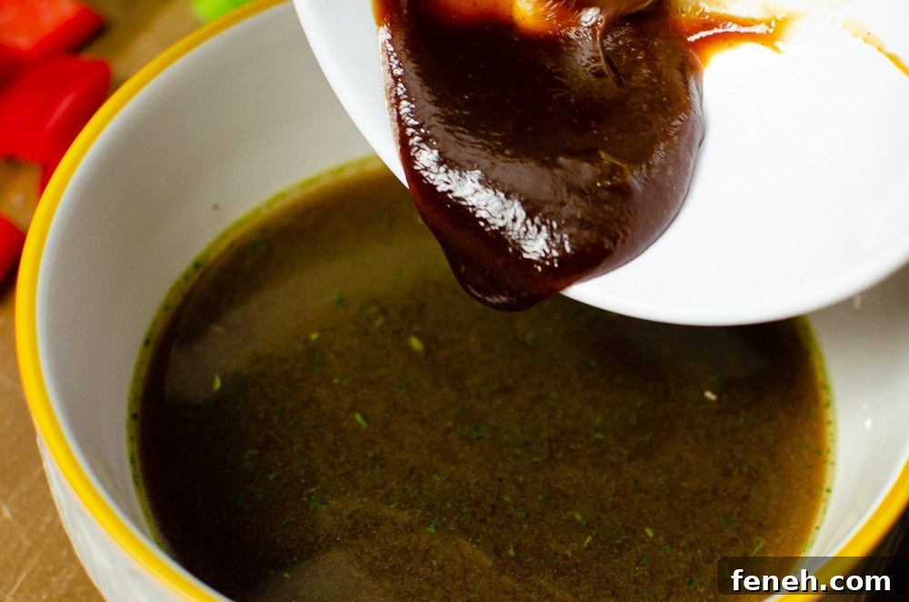Hoisin sauce being poured into a white bowl