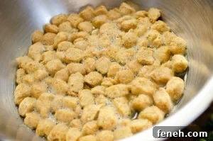 Textured Vegetable Protein in a silver bowl being soaked with vegetable stock
