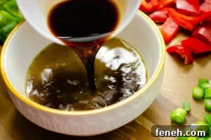 Light soy sauce being poured into a white bowl