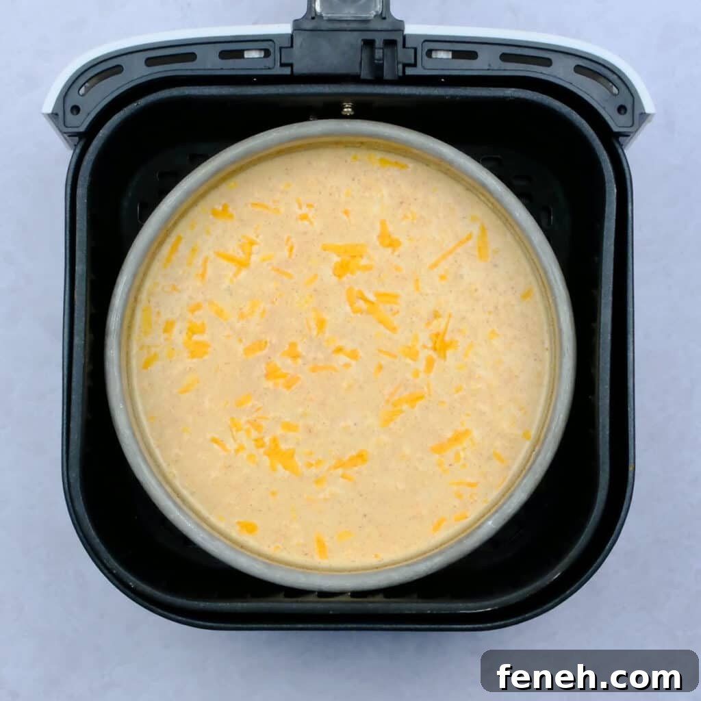 Pan with uncooked macaroni and cheese in an air fryer basket