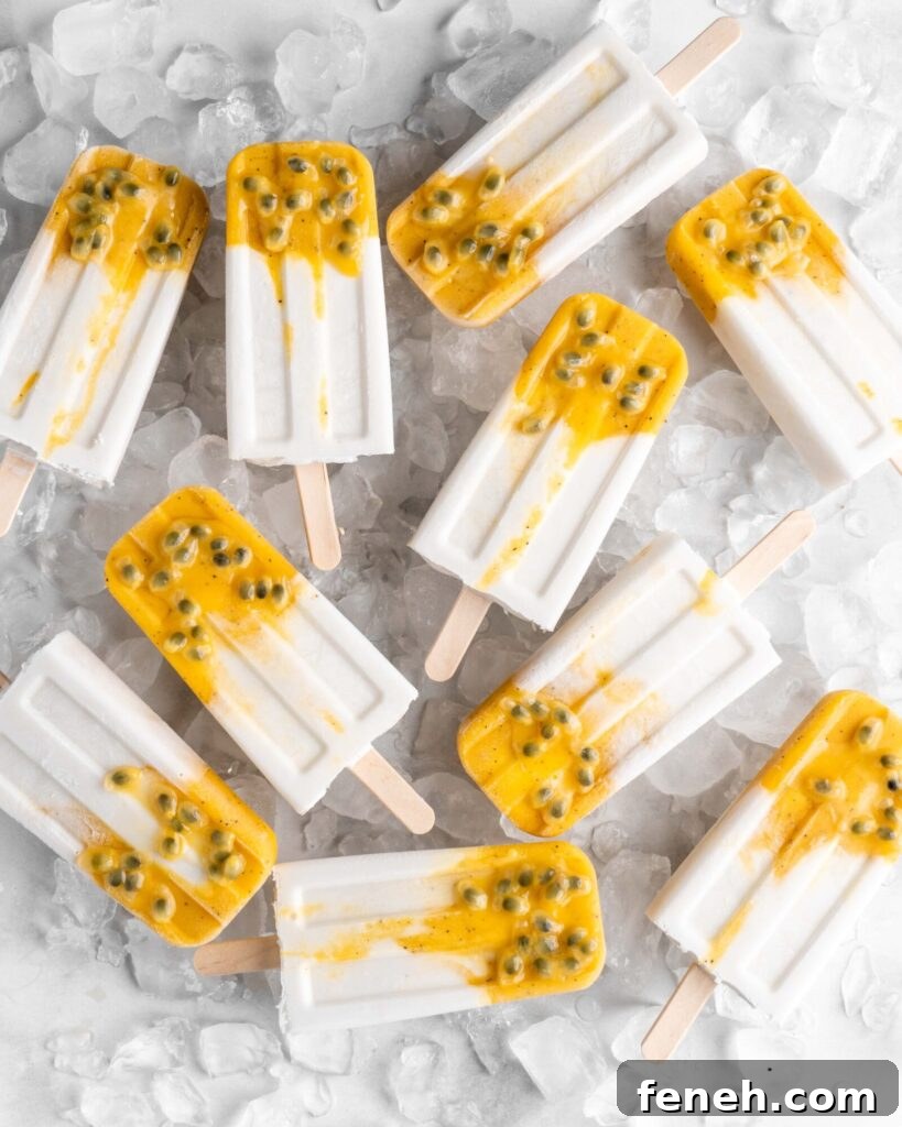 Tropical popsicles featuring mango, passion fruit, and coconut lay on a bed of ice