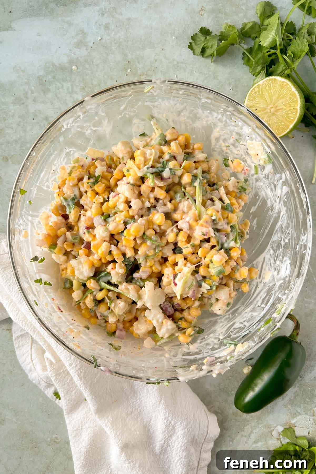 elote in a cup mixture all mixed together in a large glass mixing bowl.